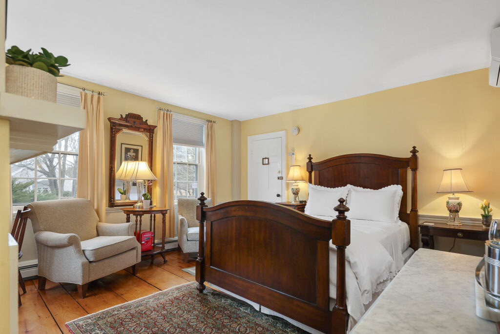 A main level room featuring a Queen-sized bed, chairs, 200-year-old wide wood planked floors overlooking Old King’s Highway