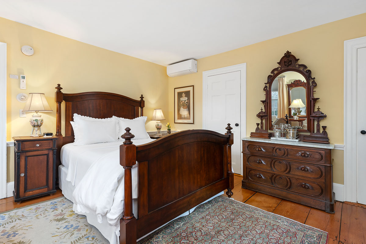 A main level room featuring a Queen-sized bed, chairs, 200-year-old wide wood planked floors overlooking Old King’s Highway