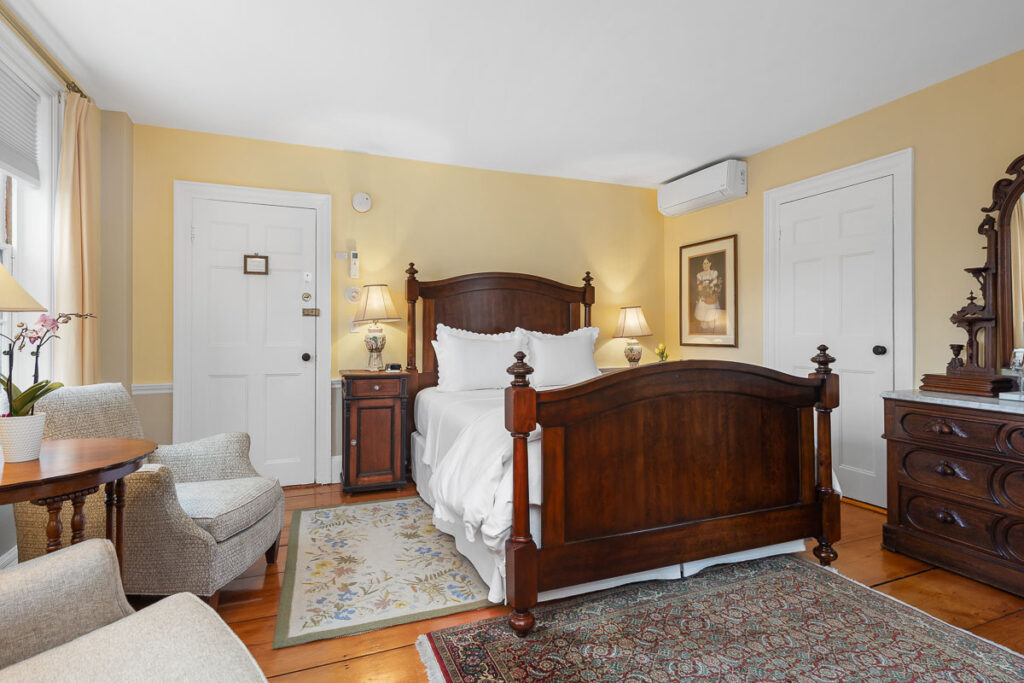 A main level room featuring a Queen-sized bed, chairs, 200-year-old wide wood planked floors overlooking Old King’s Highway